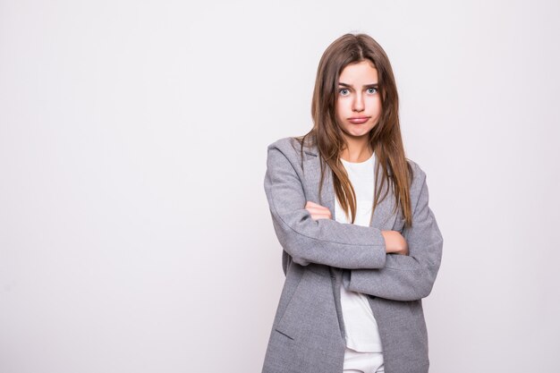 Portrait of angry woman standing with arms folded isolated on gray background