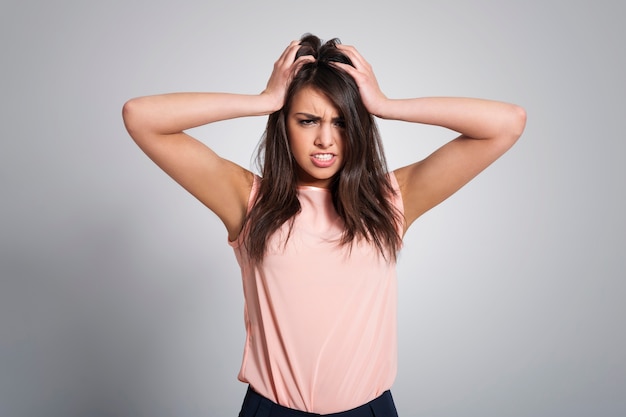 Portrait of angry woman with hand on head