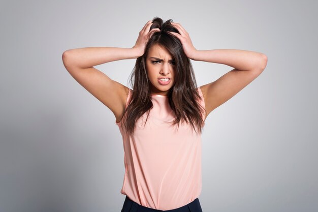 Portrait of angry woman with hand on head