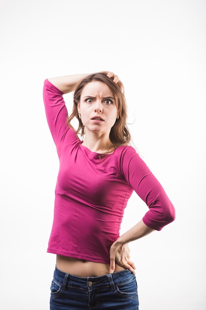 Portrait of an angry young woman standing against white background