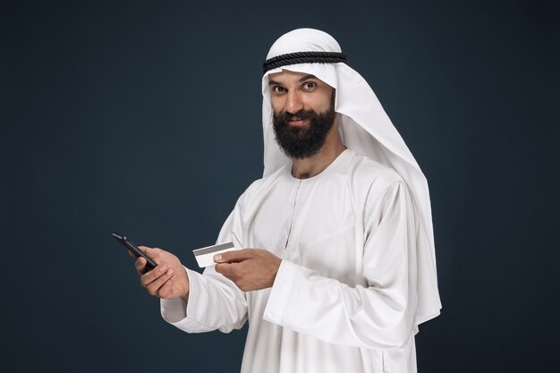 진한 파란색에 아라비아 사우디 사업가의 초상화
