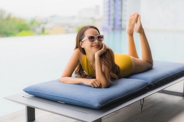 Portrait asian beautiful young woman happy smile relax around outdoor swimming pool in holiday vacation