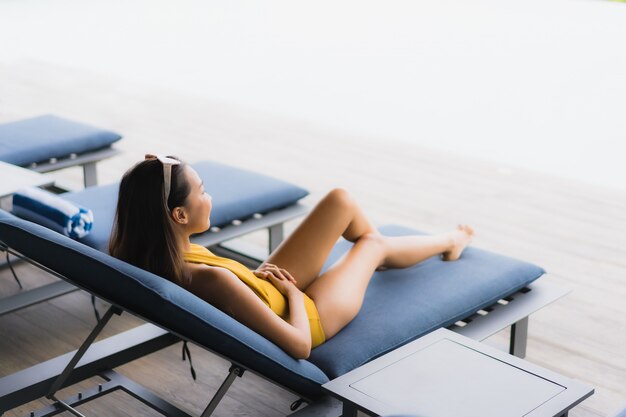 Portrait asian beautiful young woman happy smile relax around outdoor swimming pool in holiday vacation