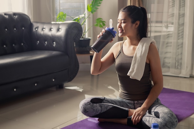 Portrait of asian charming active woman resting after workout at home