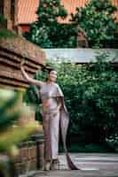 Бесплатное фото Портрет азиатской очаровательной женщины в красивой типичной тайской культуре идентичности одежды таиланда в древнем храме или известном месте с изящной позой