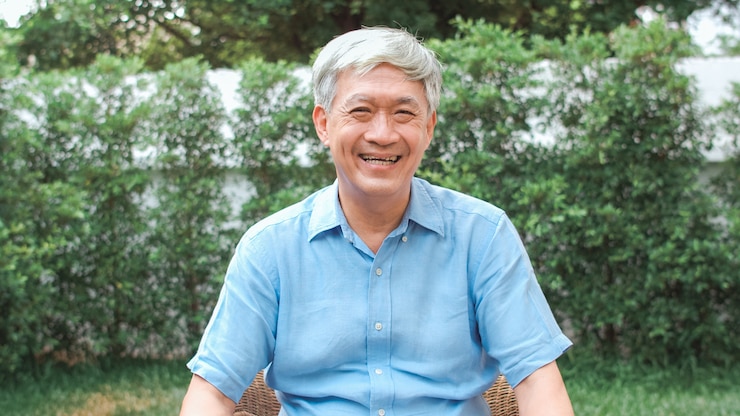 Free Photo portrait asian chinese senior man feeling happy smiling at home. older male relax toothy smile looking while lying in the garden at home in the morning concept.