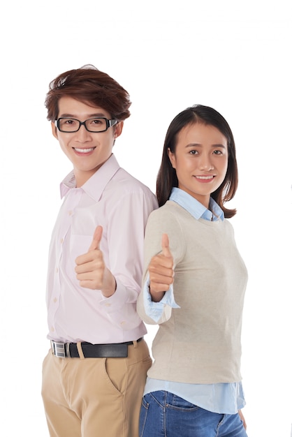 Portrait of Asian girl and boy standing back to back thumbs up 
