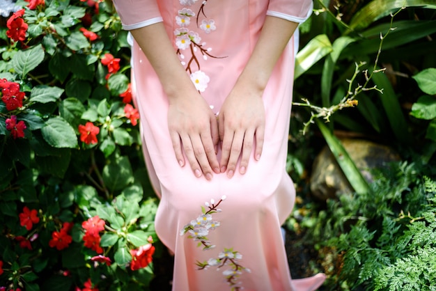 Portrait of asian girls with ao-dai vietnam traditional dress costume  sitting in flower garden