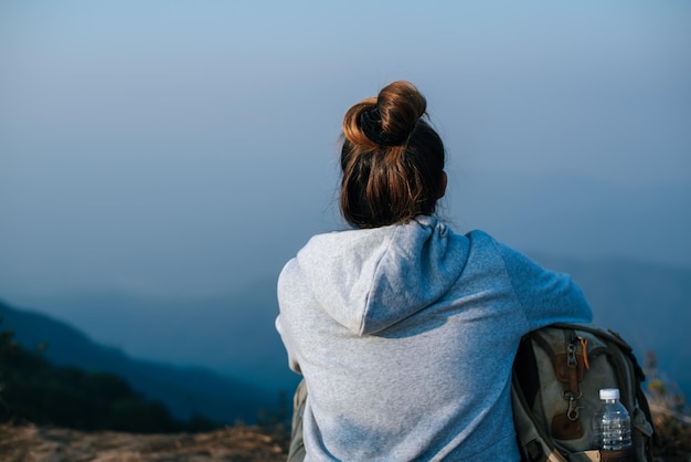 Portrait of Asian hiker woman with backpack relaxing on mountain and enjoying with copy space Travel Lifestyle wanderlust adventure concept vacations outdoor