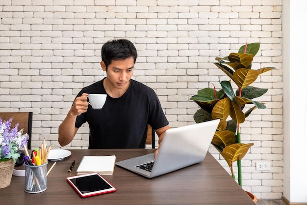 Portrait of Asian man freelancer working at home sitting at desk dining table in living room