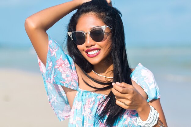 portrait of asian thai girl with sunglasses having fun on tropical beach