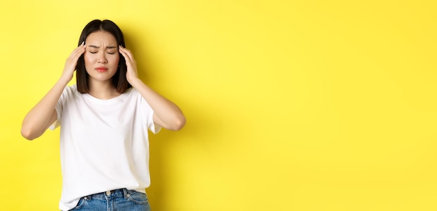 Free photo portrait of asian woman close eyes and frown from migraine touching head feeling dizzy from headache