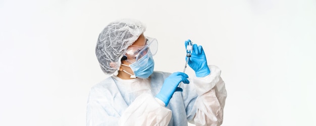 Portrait of asian woman doctor nurse vaccinating patients using syringe and covid vaccine standing i