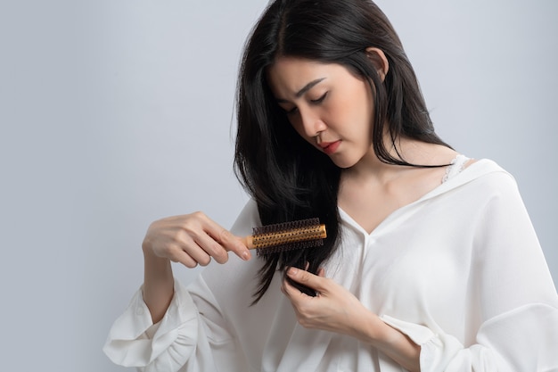 Premium Photo | Portrait of asian woman long hair with a comb and problem  hair on white.