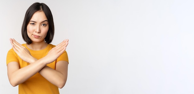 Portrait of asian woman looking serious and angry showing stop prohibit gesture taboo sign forbiddin