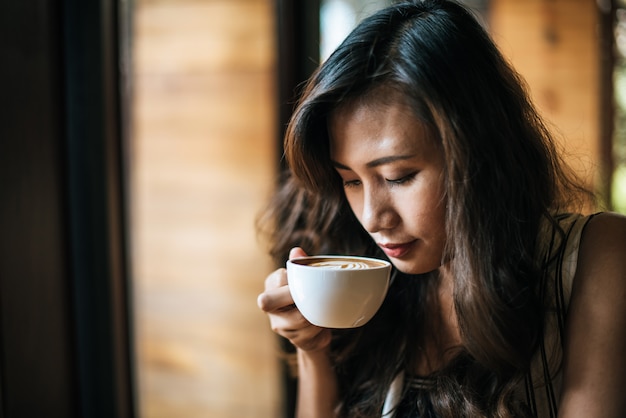 笑みを浮かべて肖像画アジア女性のコーヒーショップカフェでリラックス