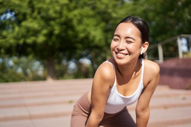 Free photo portrait of asian woman taking break breathing heavily and panting after running jogger standing and