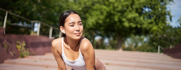 Free photo portrait of asian woman taking break breathing heavily and panting after running jogger standing and