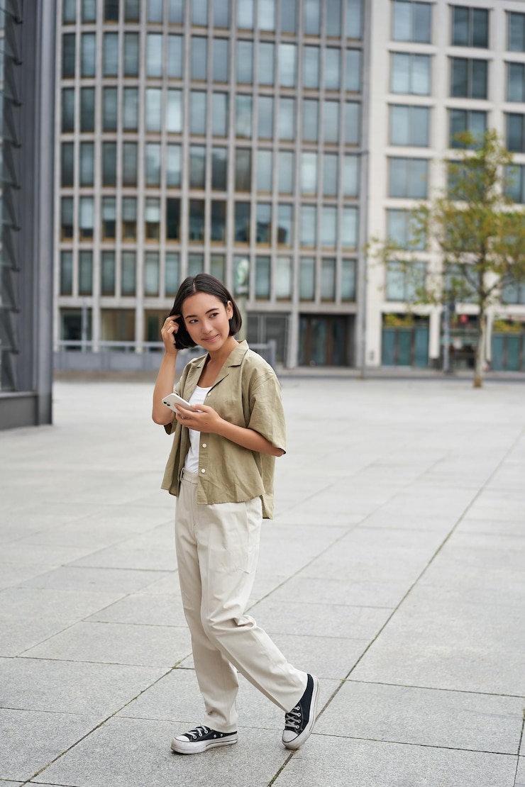 無料Photo 屋外でポーズをとるスマートフォンを持つ女の子の街の通りスタイルのショットを歩くアジアの女性の肖像画