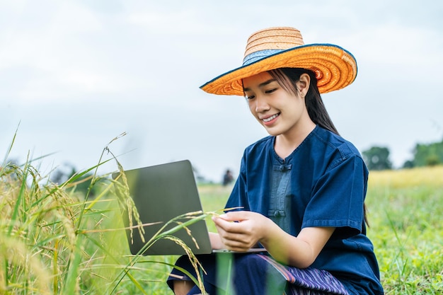 Portrait of asian young farmer woman with laptop