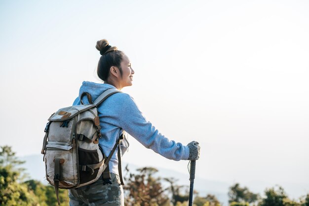 아시아 젊은 관광 여성의 초상화가 마운팅 꼭대기에서 하이킹을 하고 있으며 복사 공간이 있는 아름다운 풍경을 바라보고 있습니다. 여행 라이프스타일 방랑벽 모험 개념 휴가 야외