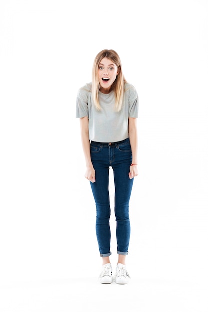 Free photo portrait of an astonished cute young woman standing with mouth opened