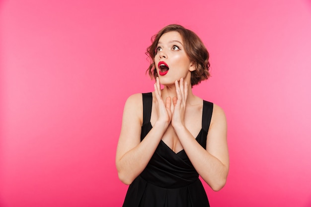 Portrait of an astonished girl dressed in black dress