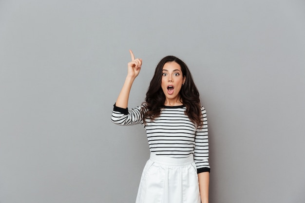 Free photo portrait of an astonished woman pointing finger