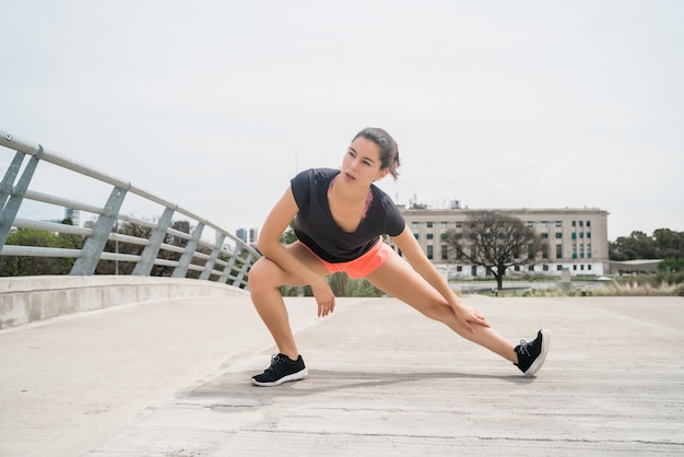 야외에서 운동을하기 전에 다리를 스트레칭 운동 여자의 초상화. 스포츠와 건강한 라이프 스타일.