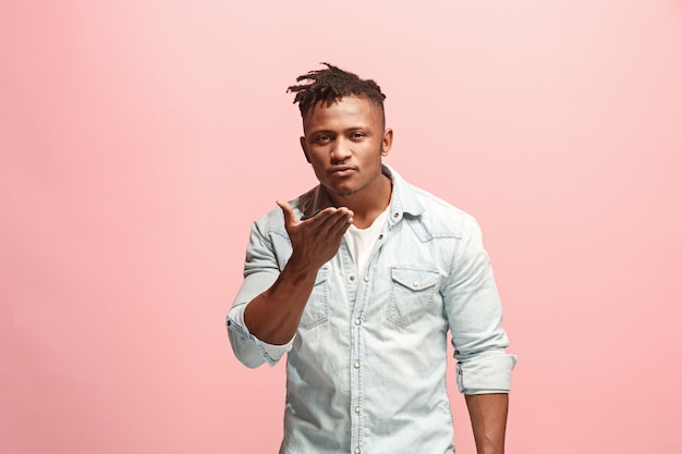 Portrait of attractive Afro-American man with air kiss isolated over pink