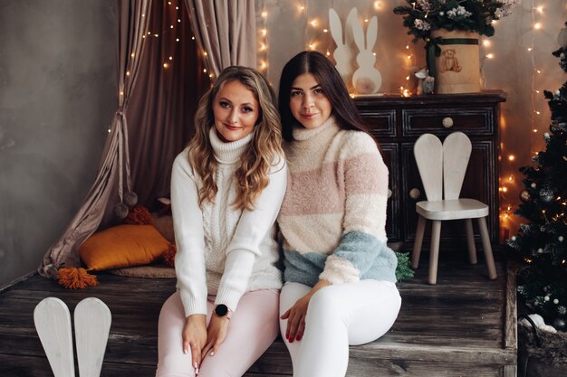 Portrait of attractive Caucasian girlfriends modestly celebrate Christmas together