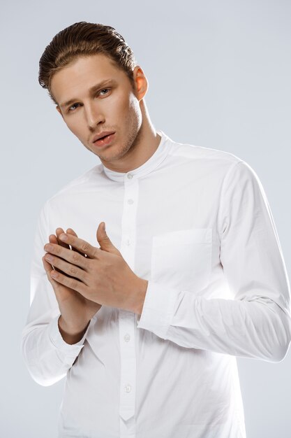 Portrait of attractive caucasian man over white wall.