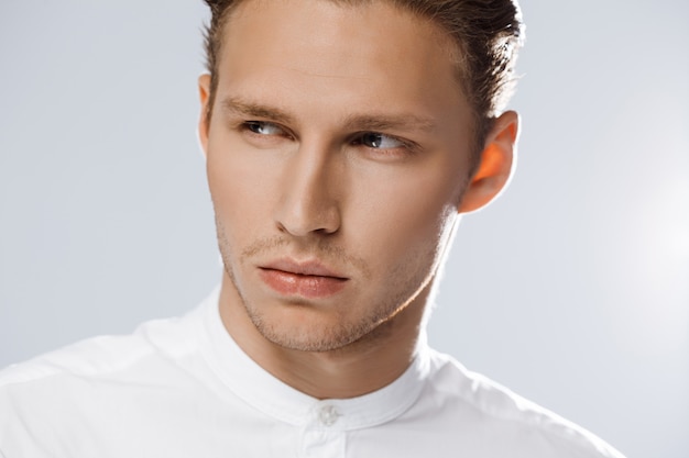 Portrait of attractive caucasian man over white wall.