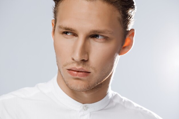 Portrait of attractive caucasian man over white wall.