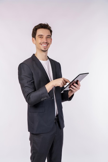 Portrait of attractive cheerful businessman using device app searching web isolated over white color background
