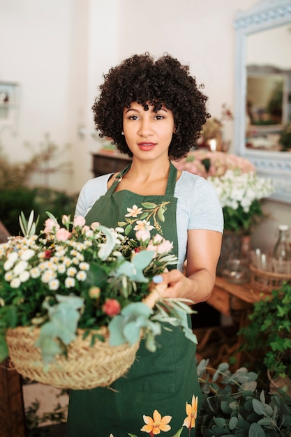 Портрет привлекательный женский флорист, холдинг корзины цветов