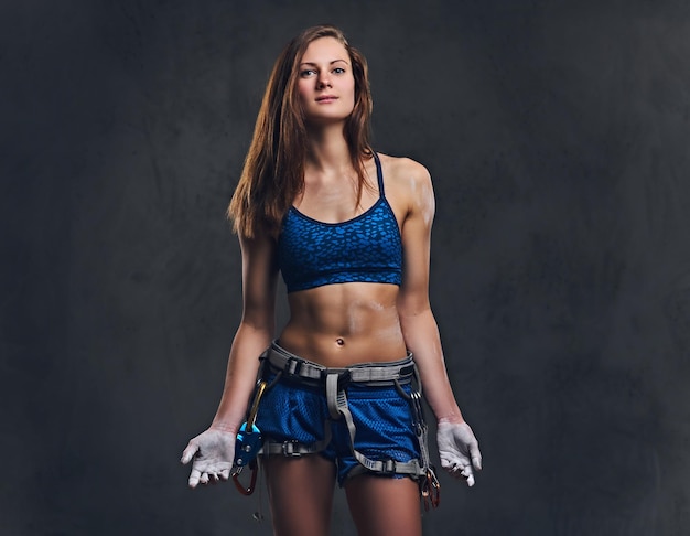 Free photo portrait of attractive female free climber with protective gear over grey background.