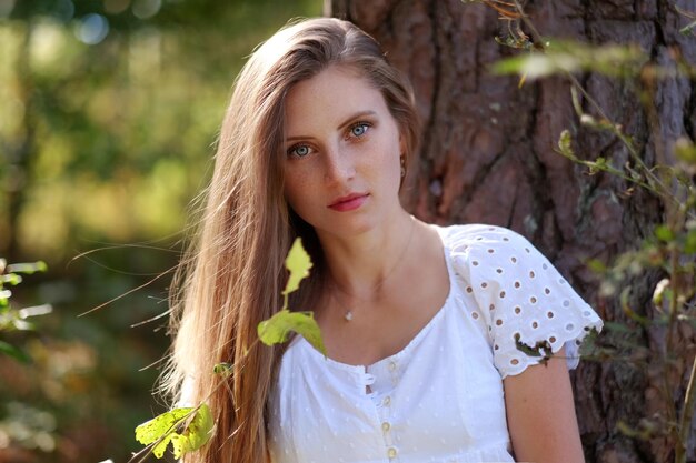 Portrait of attractive frackled woman in autumn forest.