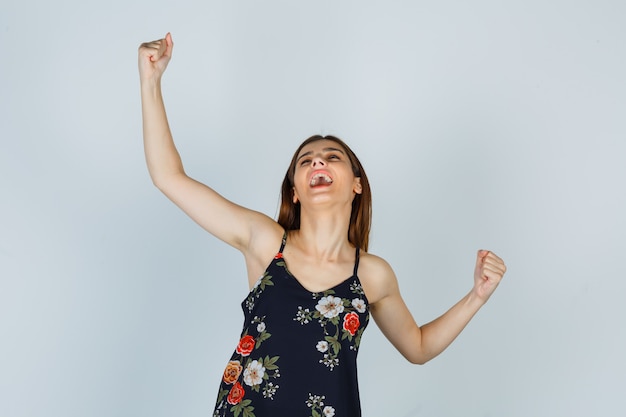 Free photo portrait of attractive lady showing winner gesture in blouse and looking happy front view