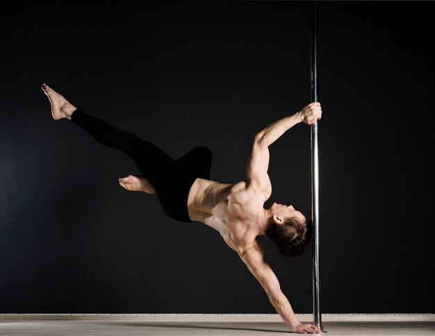 Portrait of attractive male model pole dancing