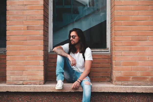 Portrait attractive man near window on urban scene