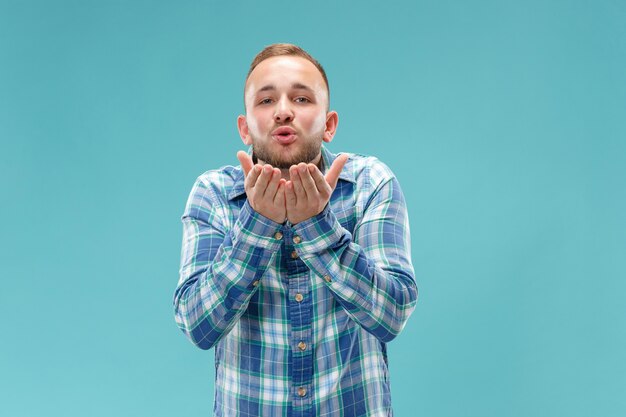 青で分離されたキスで魅力的な男の肖像