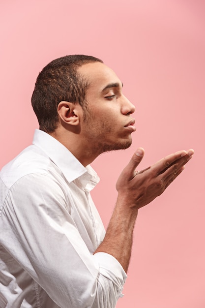 Portrait of attractive man with kiss isolated over pink