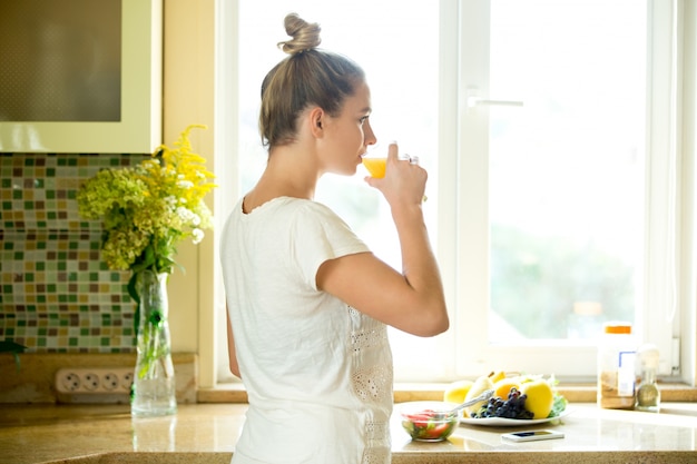 Portrait of an attractive woman drinking juice the kitchen