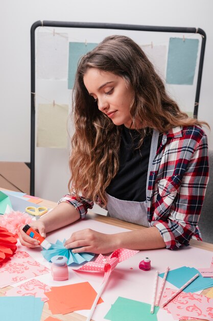 創造的な折り紙の工芸品を作る魅力的な女性の肖像画