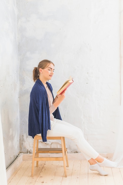 Foto gratuita ritratto di un libro di lettura donna attraente