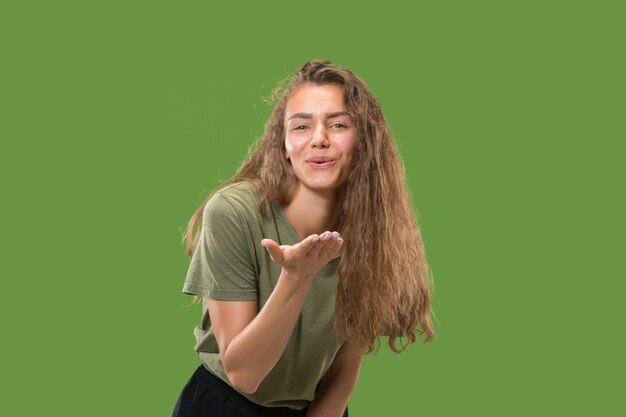 Portrait of attractive woman with kiss on lips. Green studio. Beautiful female portrait.