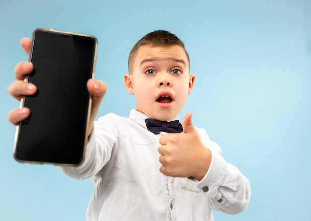 Portrait of attractive young boy holding blank smartphone