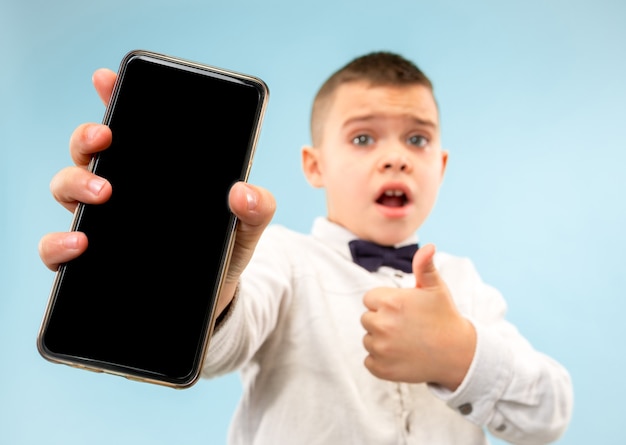 Portrait of attractive young boy holding blank smartphone