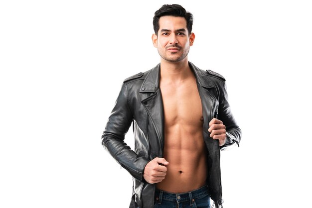 Portrait of attractive young man showing off his perfect abs while posing in open leather jacket against white background